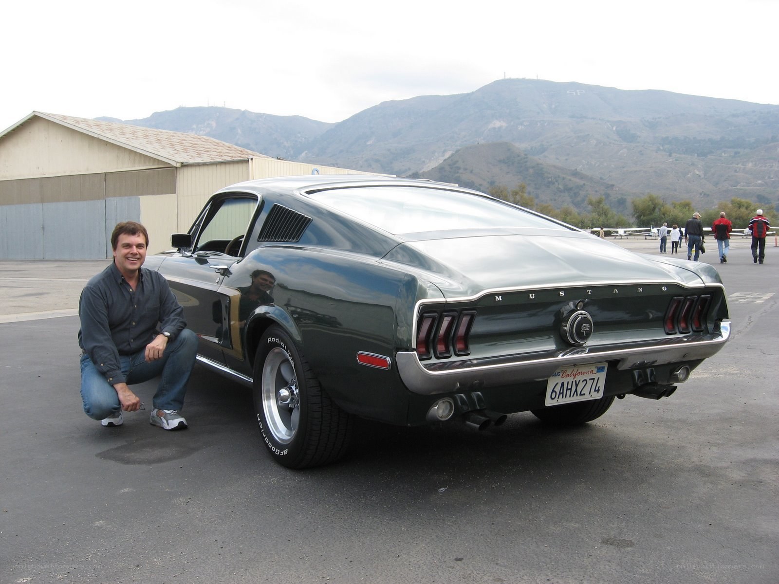 Man with classic Mustang car