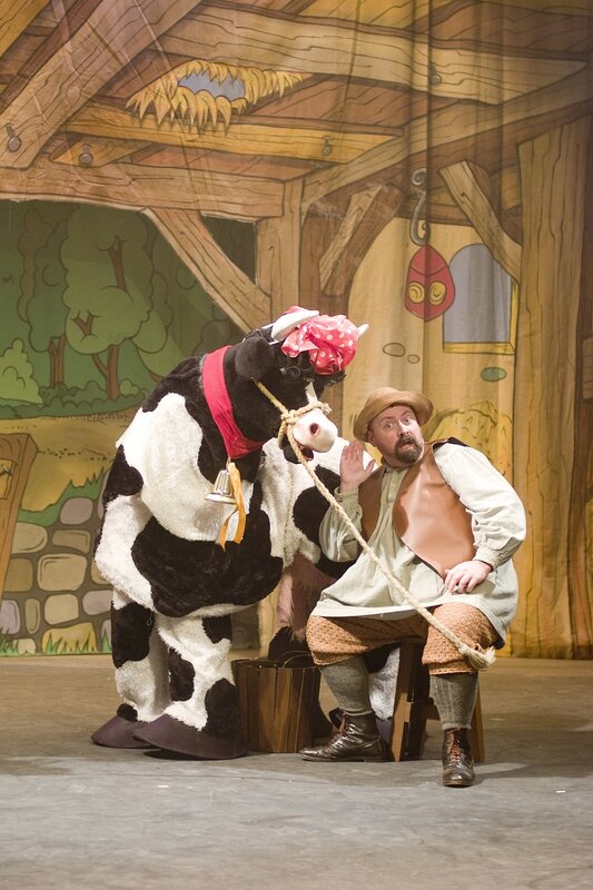 Man with cow puppet on stage