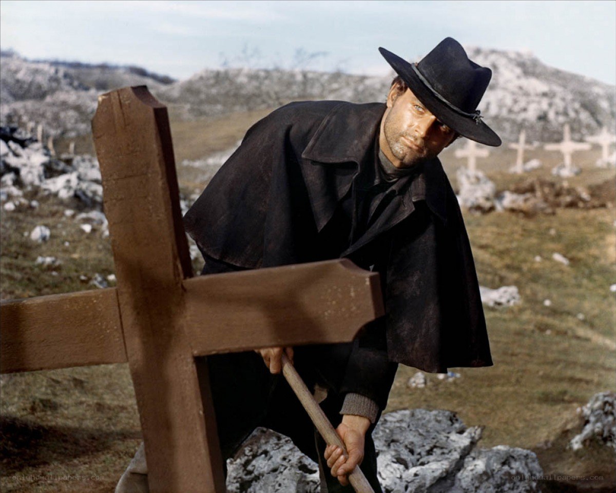 Man with cross in cemetery