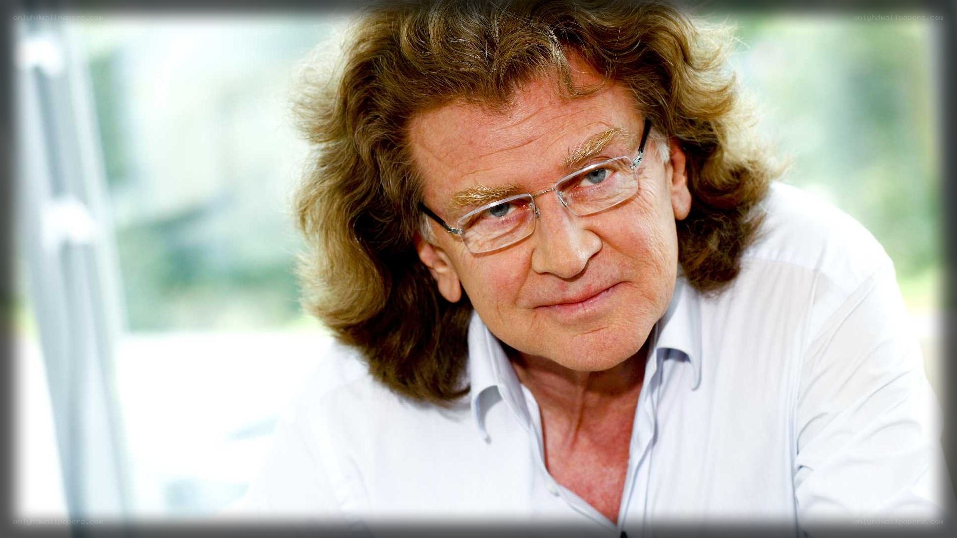 man with curly hair and glasses