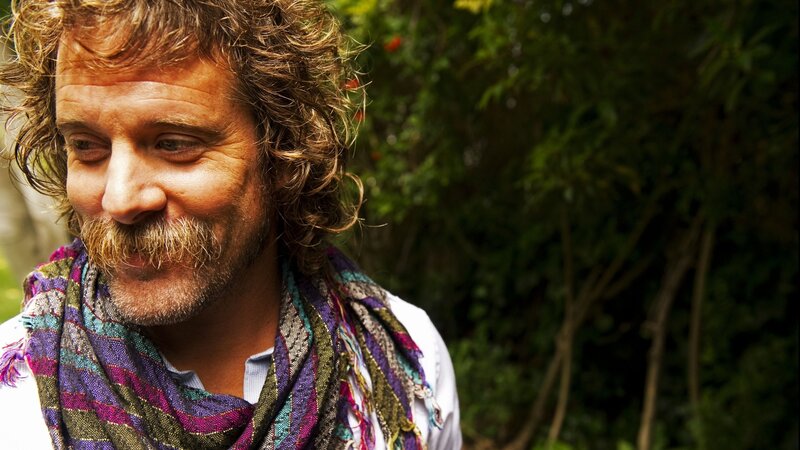 man with curly hair and scarf