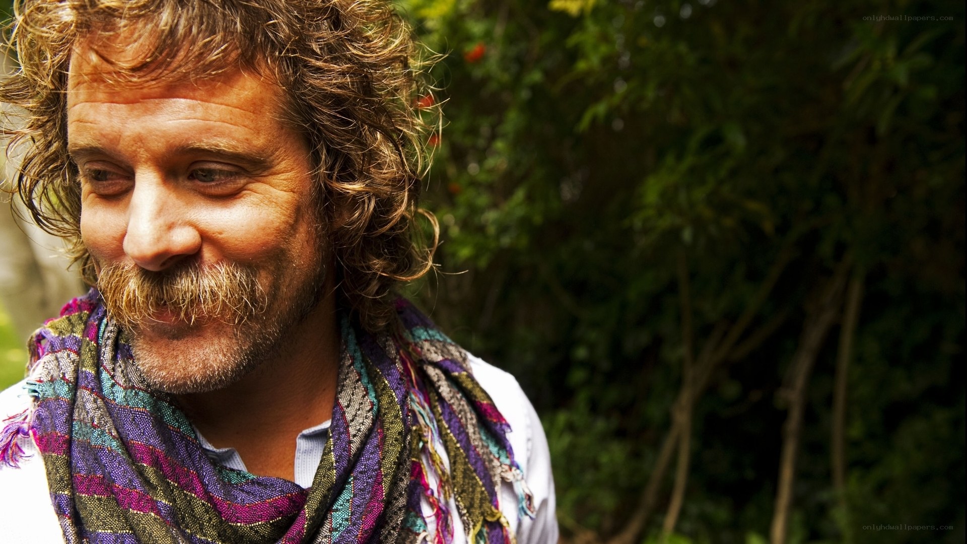 man with curly hair and scarf