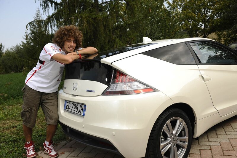 Man with curly hair by white car