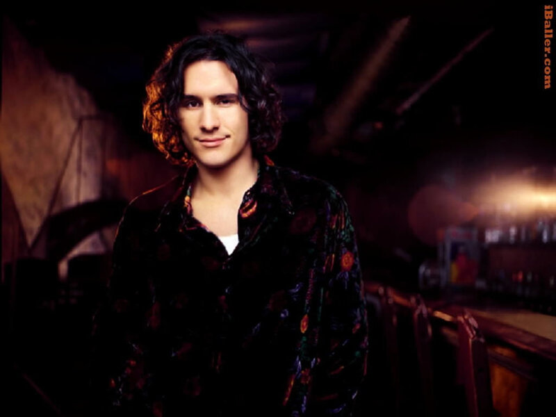 man with curly hair in dark room