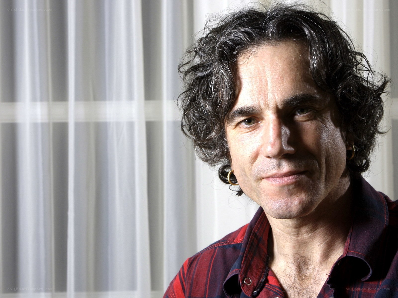 man with curly hair in plaid shirt