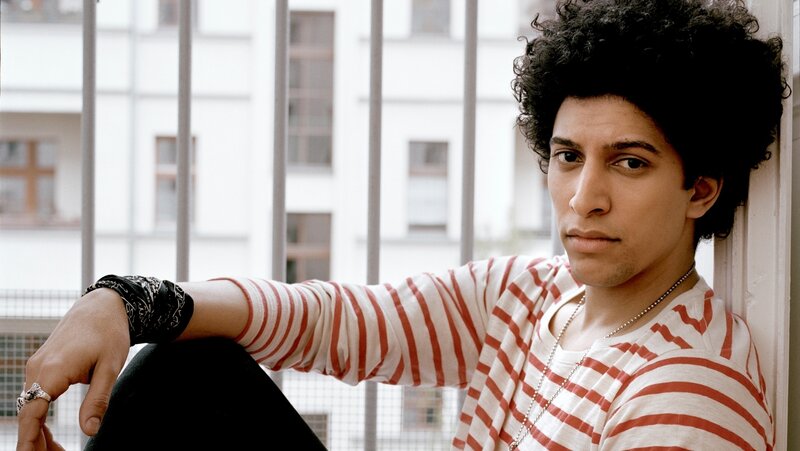 man with curly hair in striped shirt