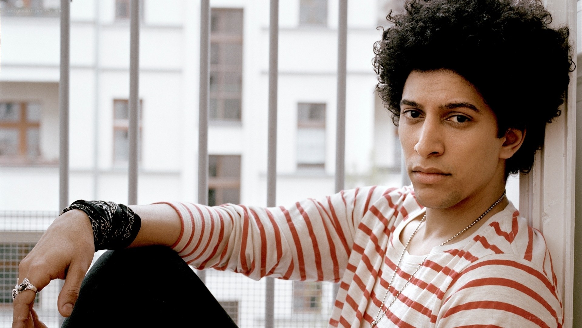 man with curly hair in striped shirt