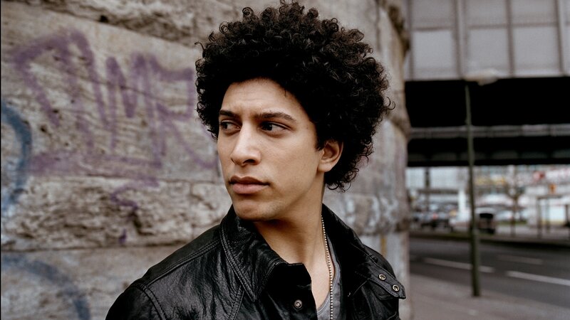 man with curly hair in urban setting