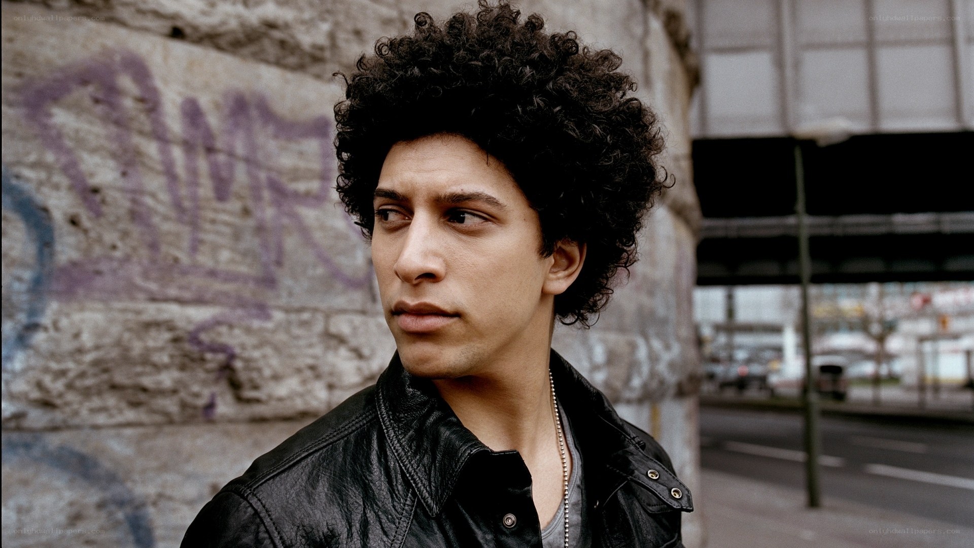 man with curly hair in urban setting