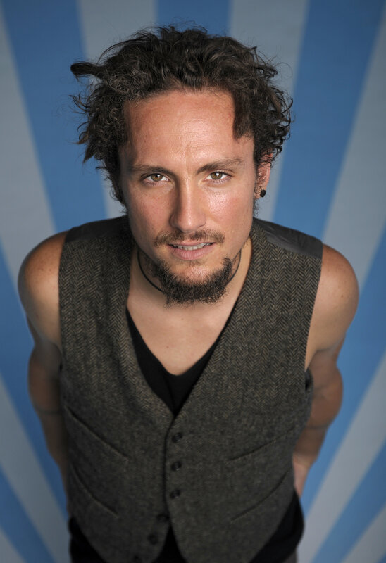 man with curly hair in vest