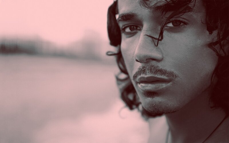 man with curly hair looking at camera