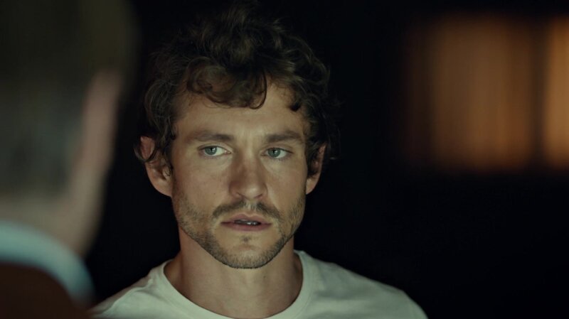 man with curly hair looking at someone