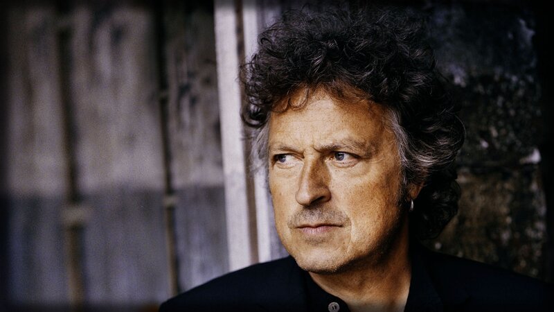 man with curly hair looking away