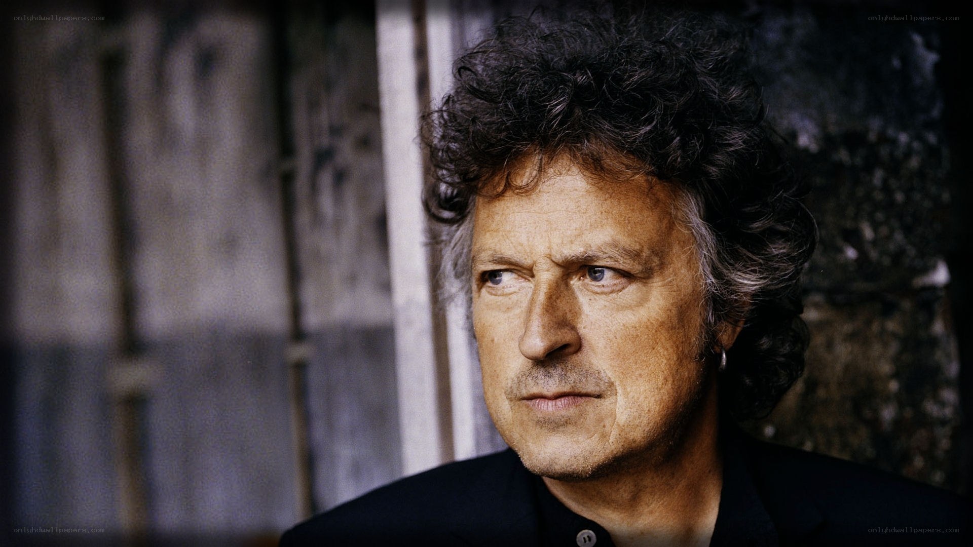 man with curly hair looking away