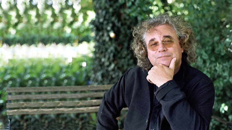 man with curly hair on bench