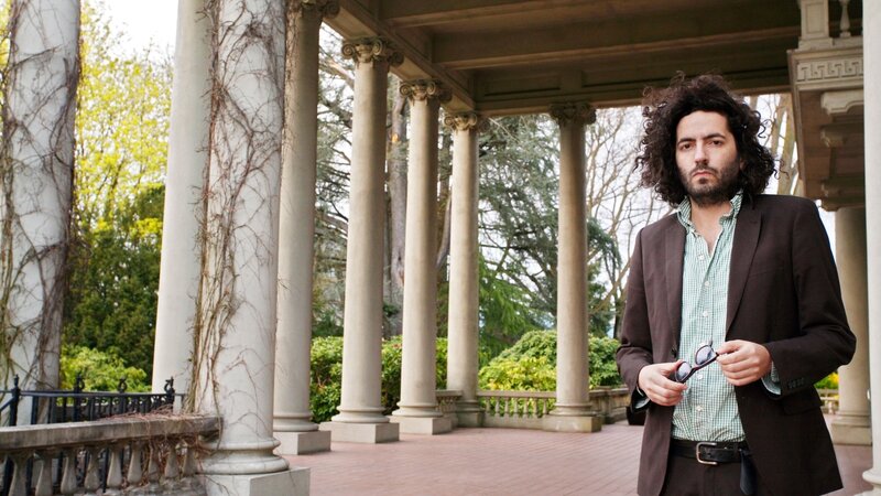 man with curly hair on porch