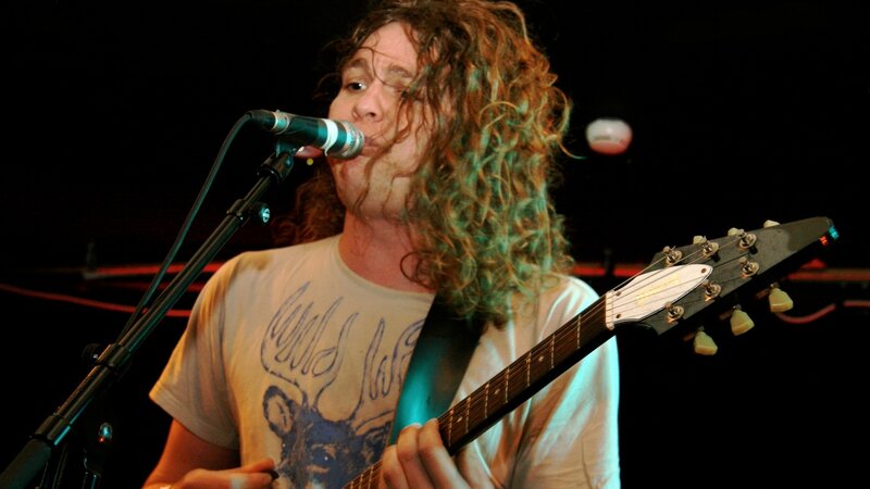 Man with Curly Hair Playing Guitar — Black