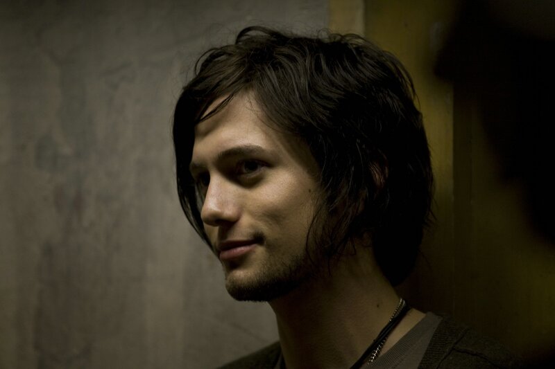 man with dark hair in dim light