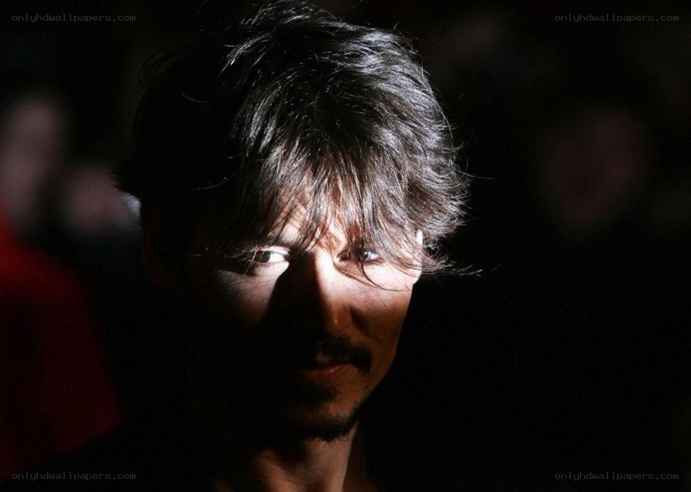man with dark hair in shadow