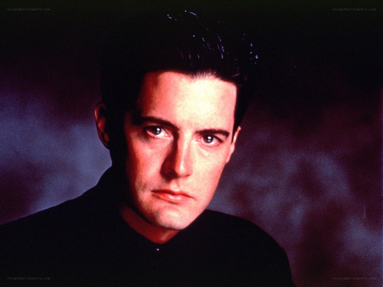 Man with dark hair in studio portrait