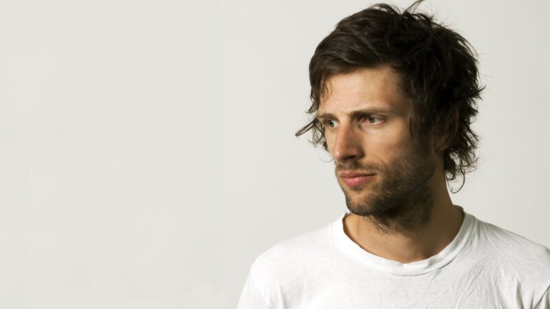 man with dark hair in white shirt