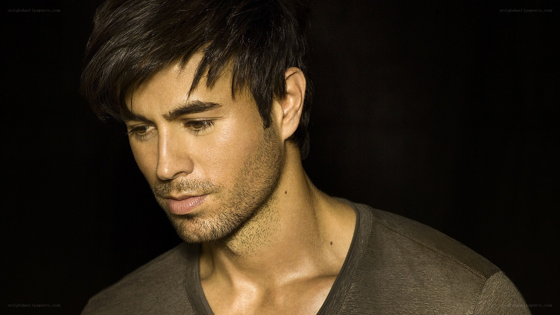 man with dark hair looking down