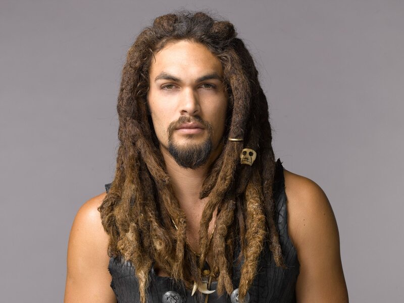 man with dreadlocks and skull charm