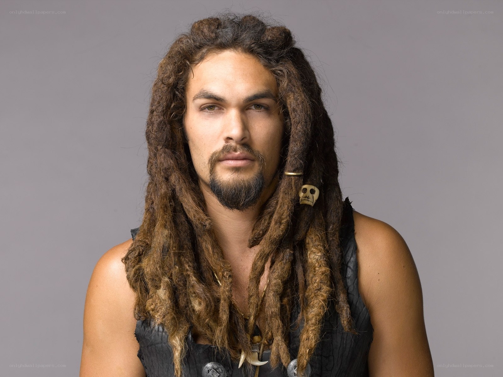 man with dreadlocks and skull charm