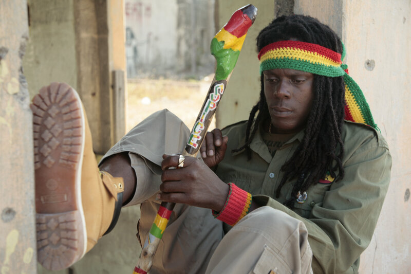 Man with dreadlocks holding a staff
