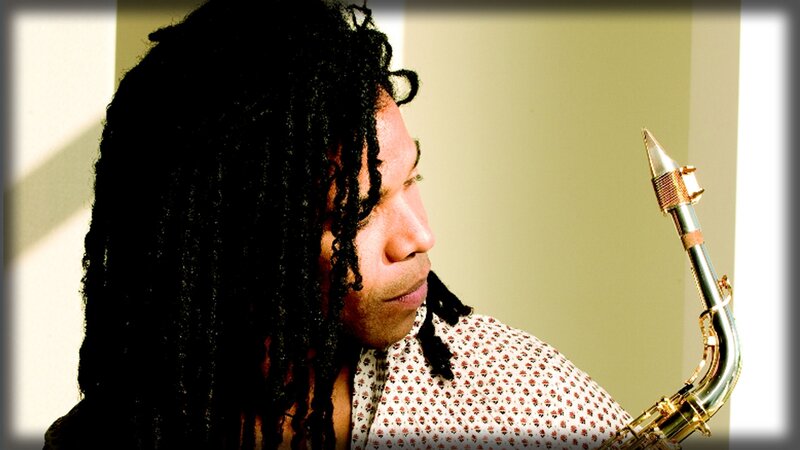 man with dreadlocks holding saxophone