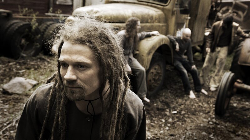man with dreadlocks in junkyard