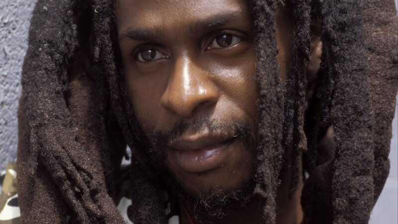 man with dreadlocks looking at camera
