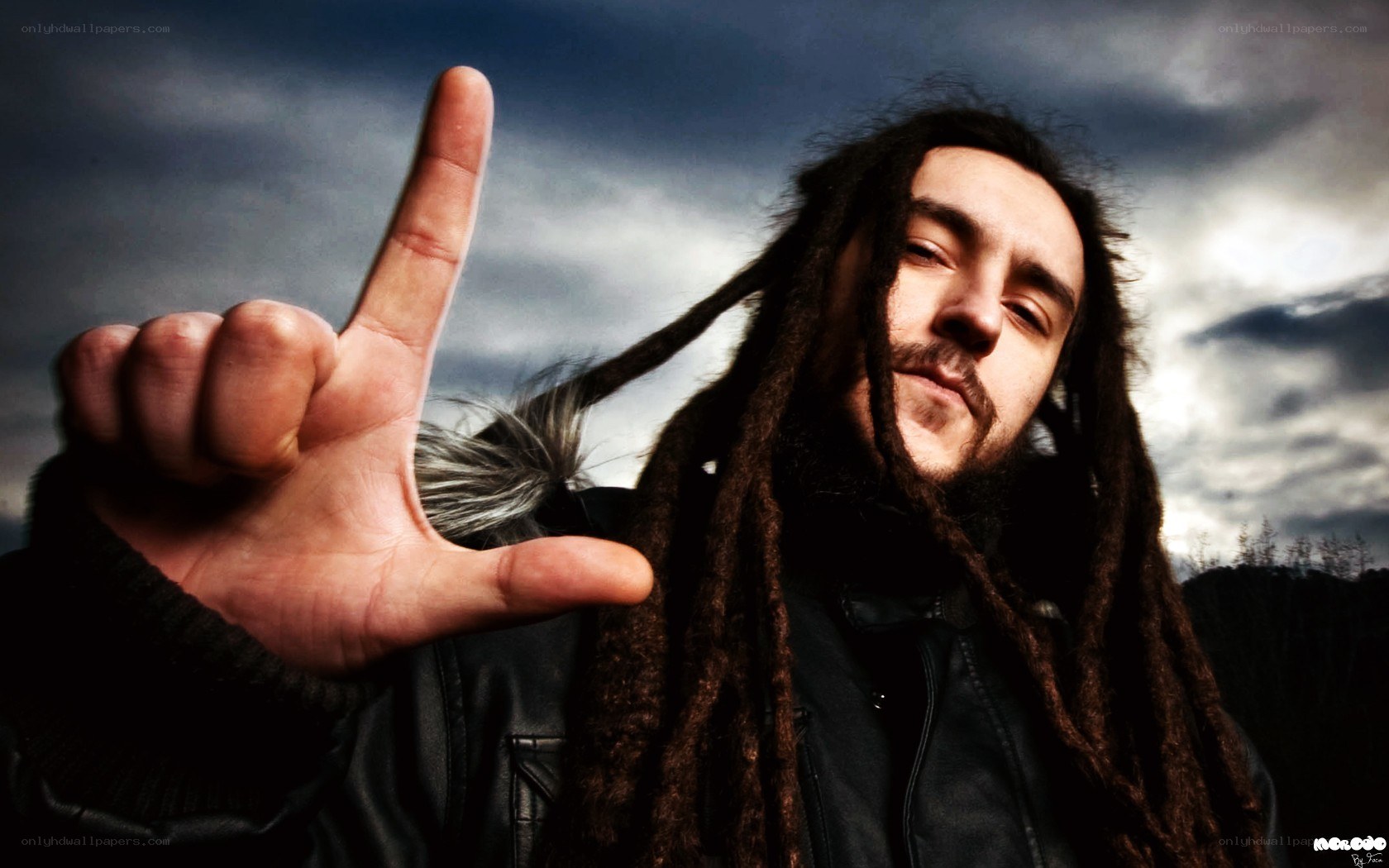 man with dreadlocks making hand gesture