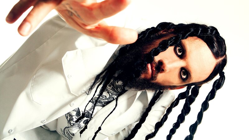 man with dreadlocks reaching forward