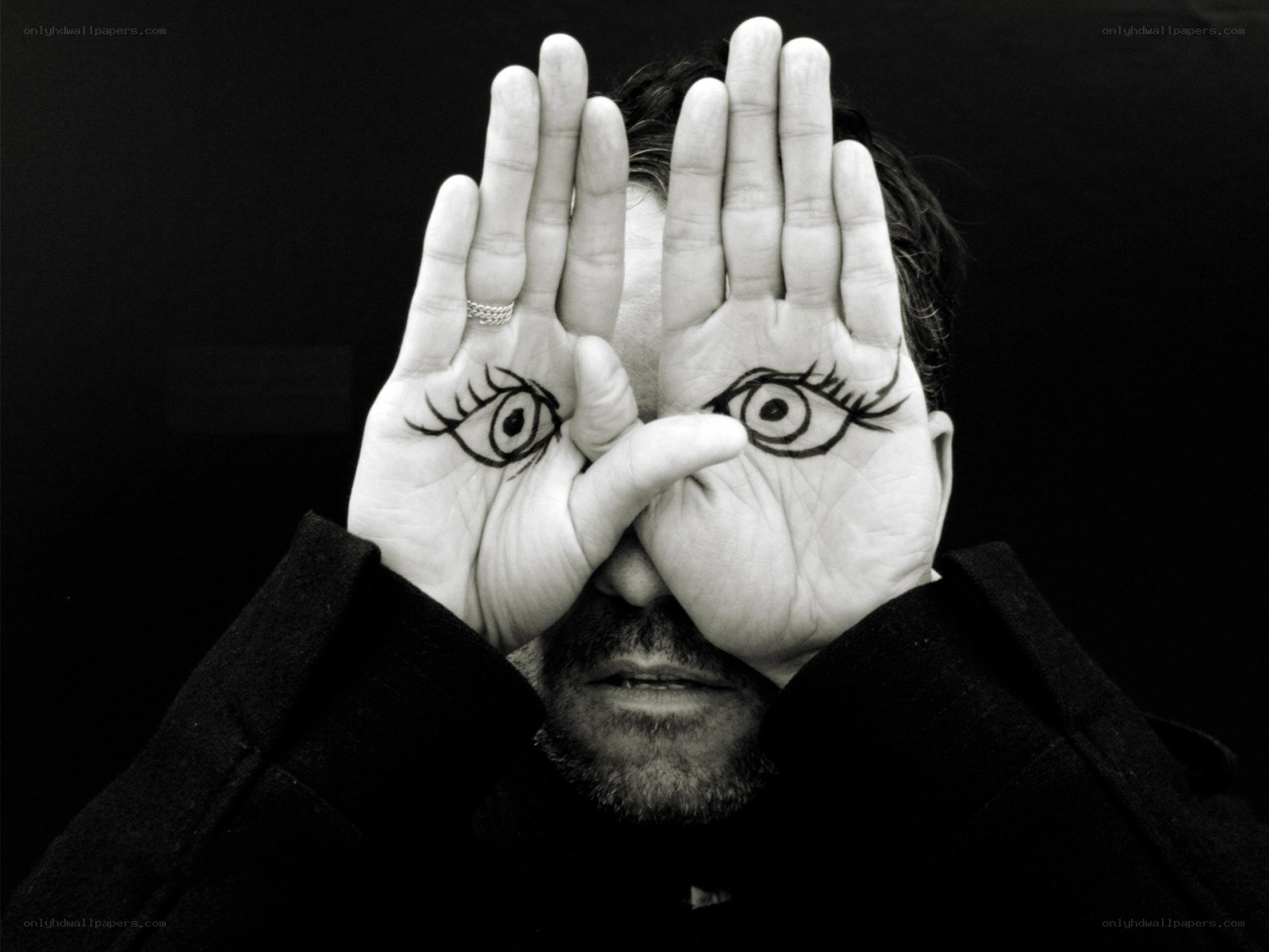 Man with eyes drawn on hands