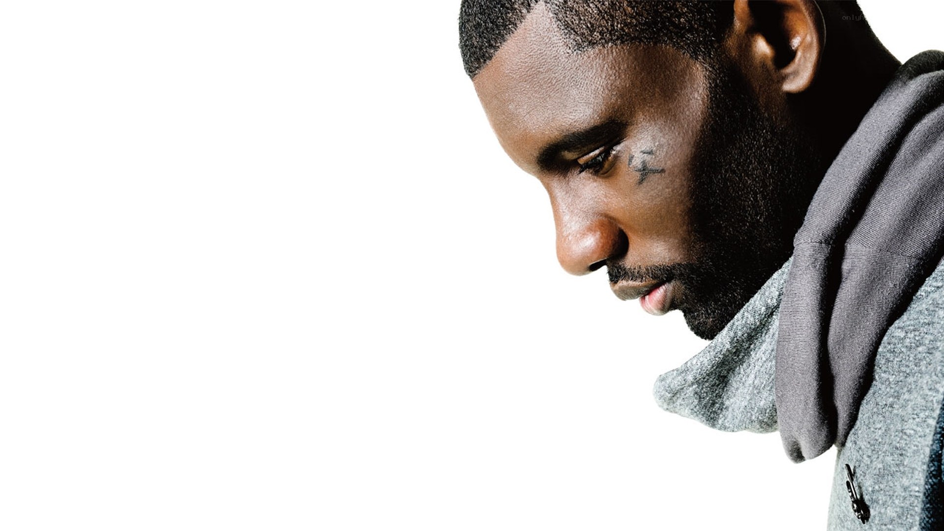 man with facial tattoo looking down