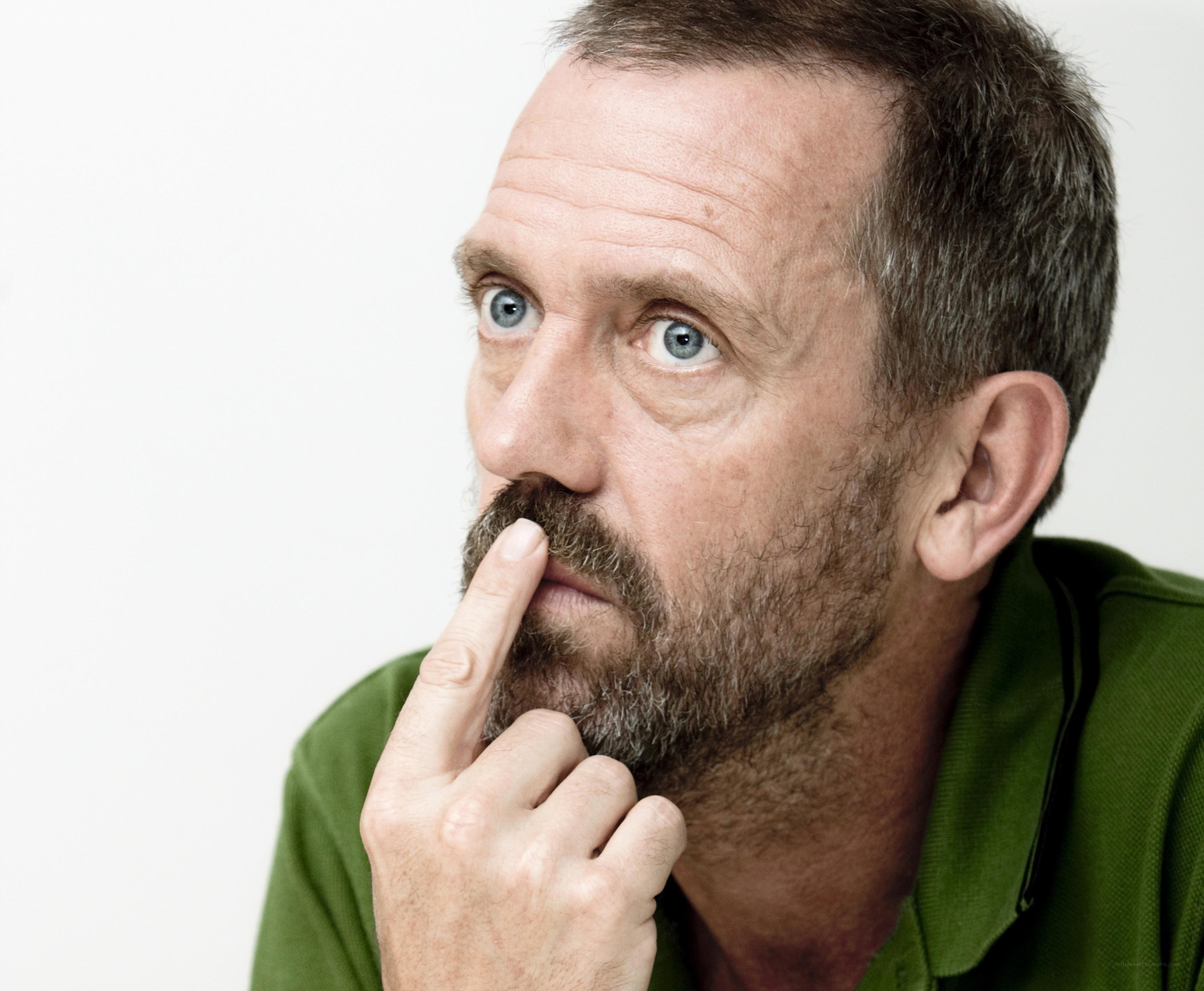 man with finger on mustache