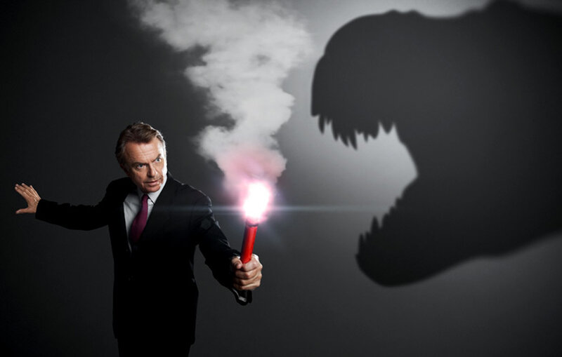Man with flare facing dinosaur shadow