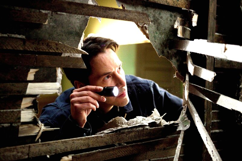Man with flashlight in debris