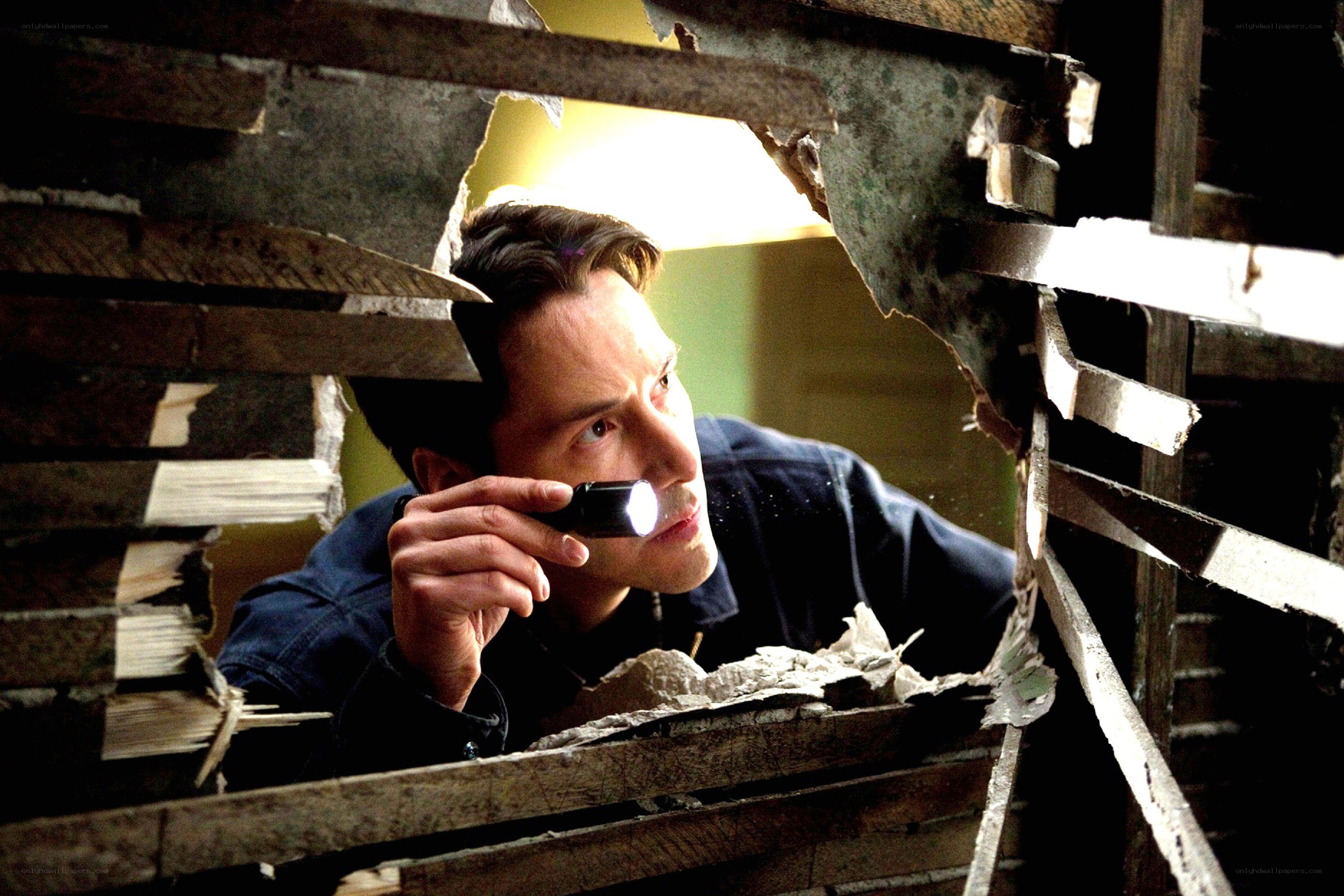 Man with flashlight in debris