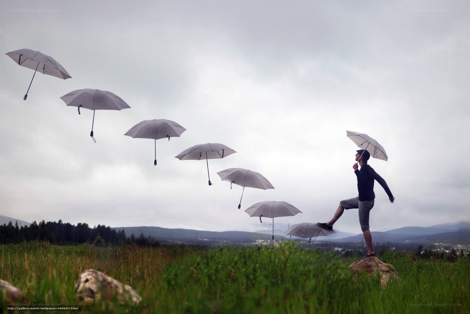 Man with floating umbrellas