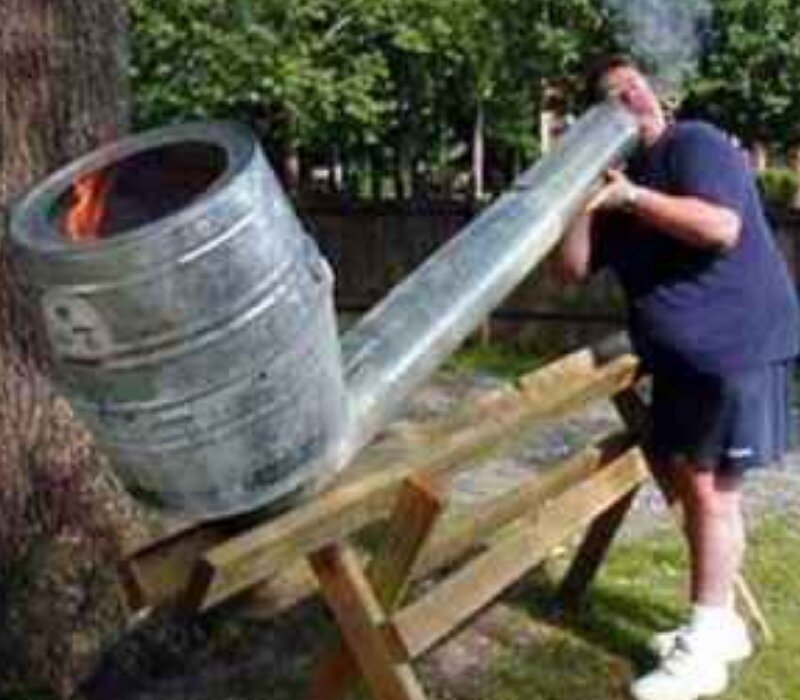 man with giant pipe sculpture