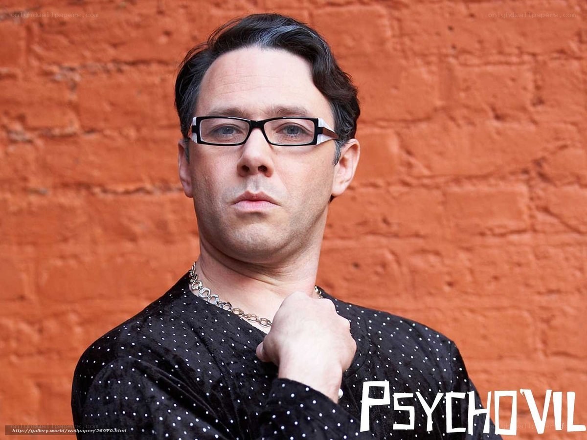man with glasses against brick wall