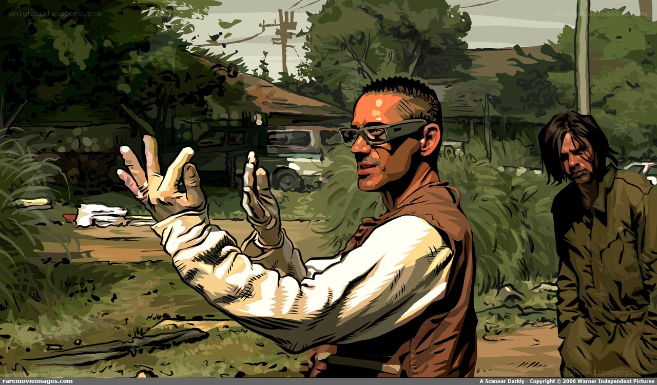 man with glasses gesturing outdoors