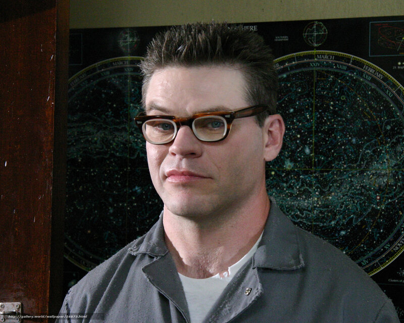 man with glasses in front of star chart