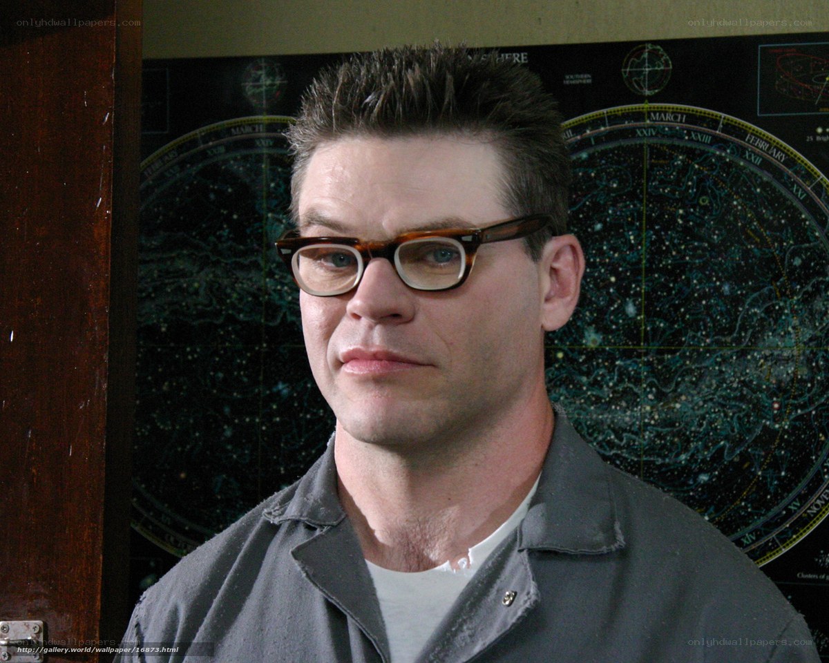 man with glasses in front of star chart