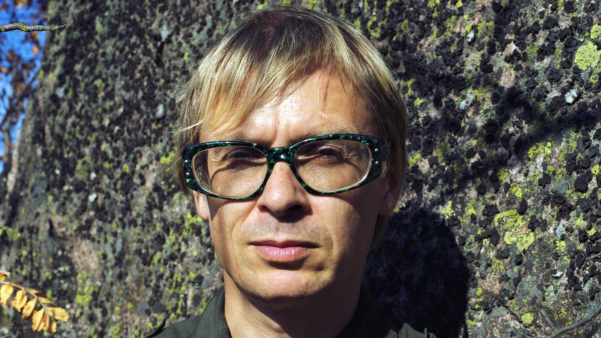 man with glasses in front of tree