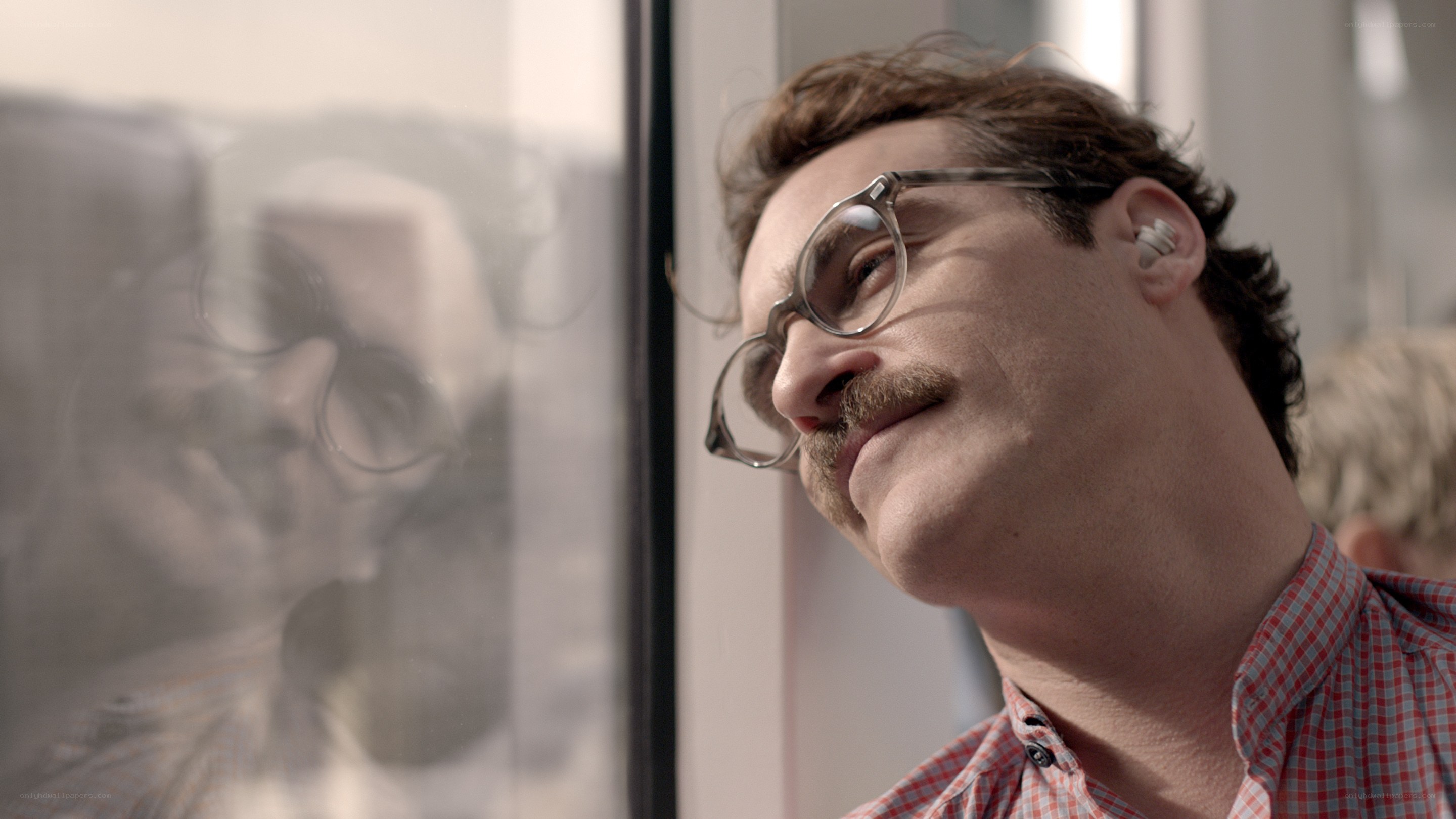 man with glasses looking out window