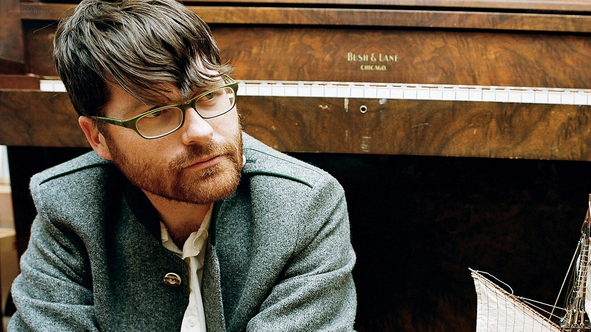 man with glasses near piano