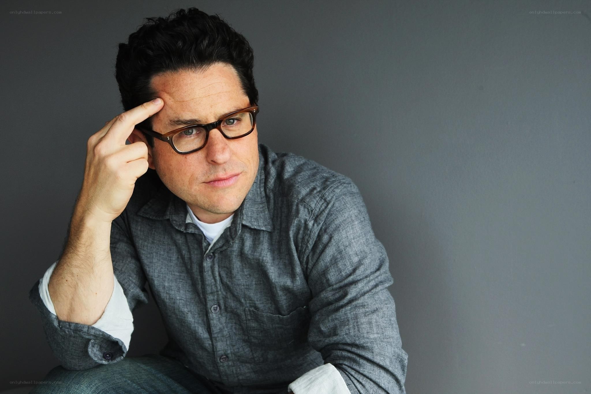 man with glasses touching his head